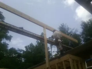 Carpenter setting a ridge beam over a new addition frame — Ice Dam Removal by Roofing Brothers in Fort Pierre