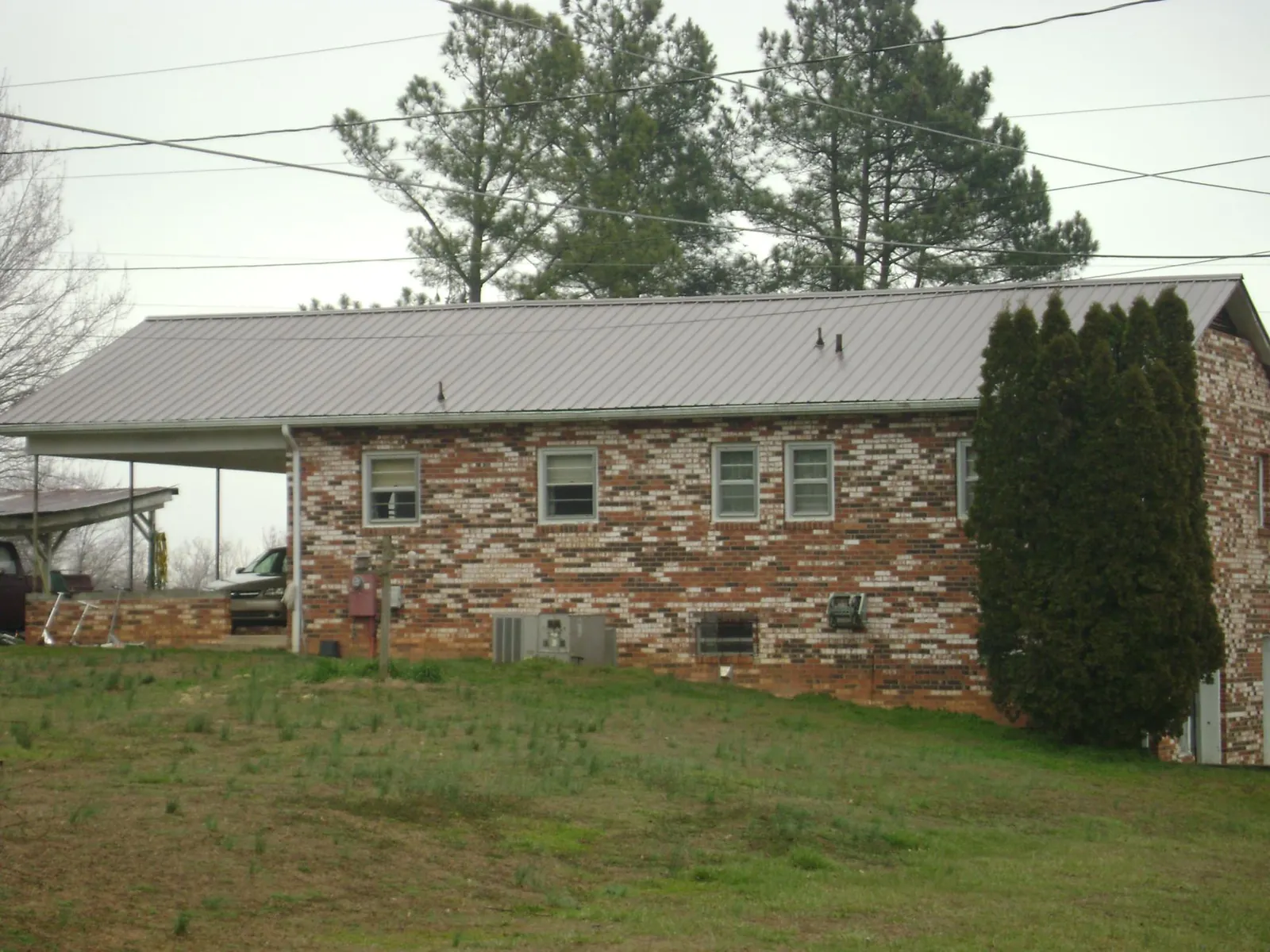 Gray metal roof on a brick split level home with a carport in Fort Pierre