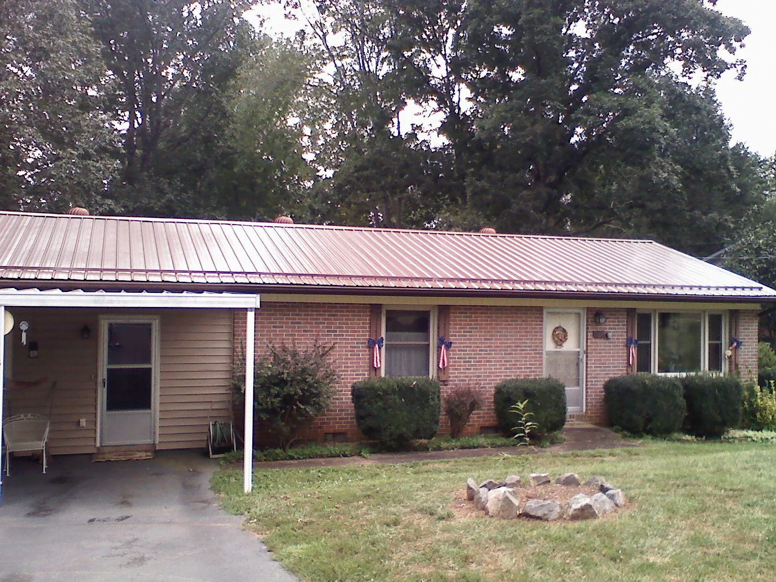Bronze metal roof and carport on a brick ranch home — Roof Repair work by our crew in Fort Pierre