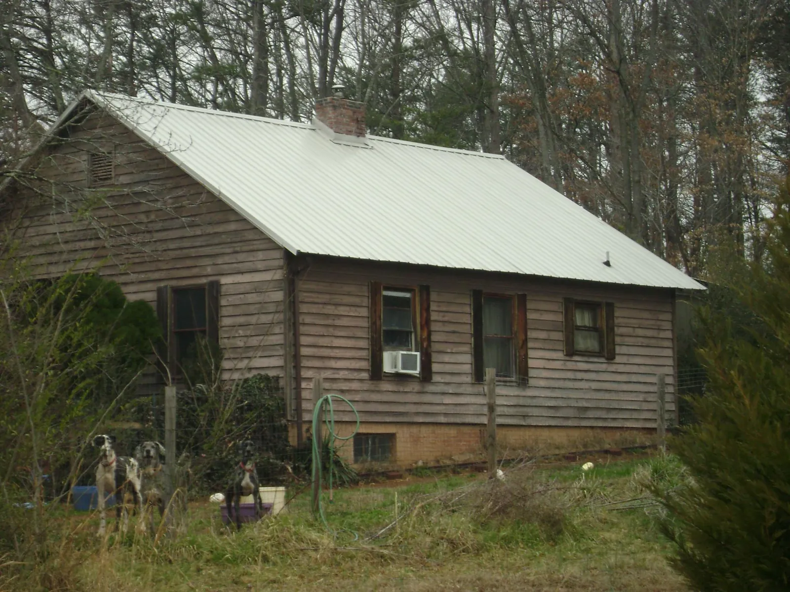White metal roof on an old wood sided farmhouse, from a Asphalt Shingle Roof Repair job in Fort Pierre